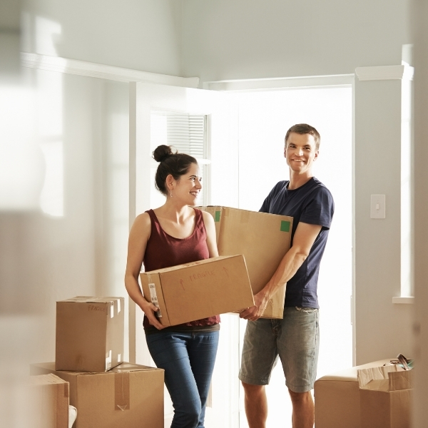 Couple holding moving boxes
